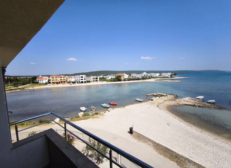 CHORVÁTSKO - Apartmány 1.rad od mora - SUKOŠAN, ZADAR - Výhľad z 1-izbového bytu v Sukošane s plážou a pobrežím na obzore.