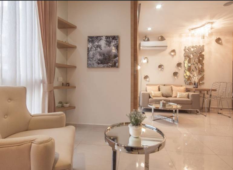 1 IZBOVÝ APARTMÁN A (1 SPÁLŇA + 1 OBÝV. IZBA) CITY GARDEN OLYMPUS  - Štýlový obývací priestor s pohodlným kreslom a dekoráciami v 2-izbovom byte.
