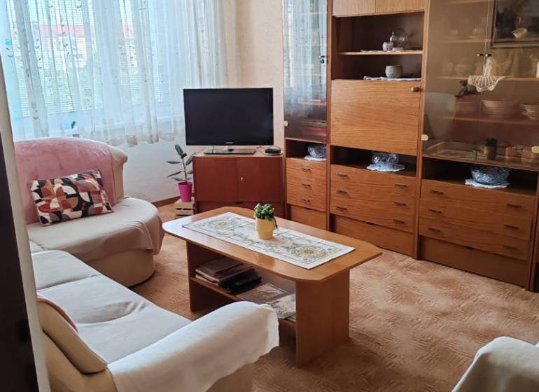 REZERVOVANÉ - SENEC - EXKLUZÍVNE IBA U NÁS - NA PREDAJ 3 izbový byt v  - Obývacia izba so sedačkou, televízorom a drevenou skriňou v 3-izbovom byte.