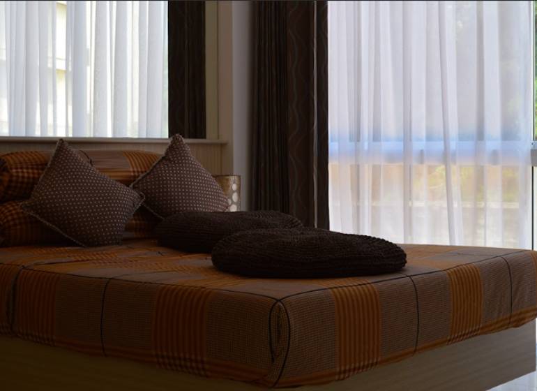 1 IZBOVÝ APARTMÁN (1 SPÁLŇA + 1 OBÝV. IZBA) THE CLOUD PATTAYA - Posteľ s hnedým posteľným prádlom a vankúšmi v 2-izbovom byte.