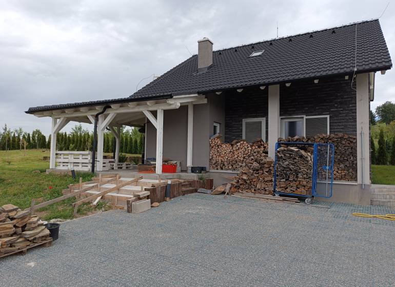 Rekreačná chata Nová Baňa - Drozdovo - Vidím dom s drevenou terasou a uskladnenými polenami na dvore.