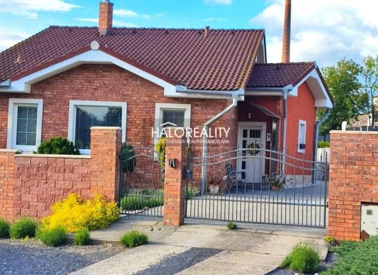 REZERVOVANÉ - Predaj, rodinný dom Kalinovo - EXKLUZÍ... - Rodinný dom v Kalinove s tehlovou fasádou, ozdobným plotom a záhradnými prvkami.