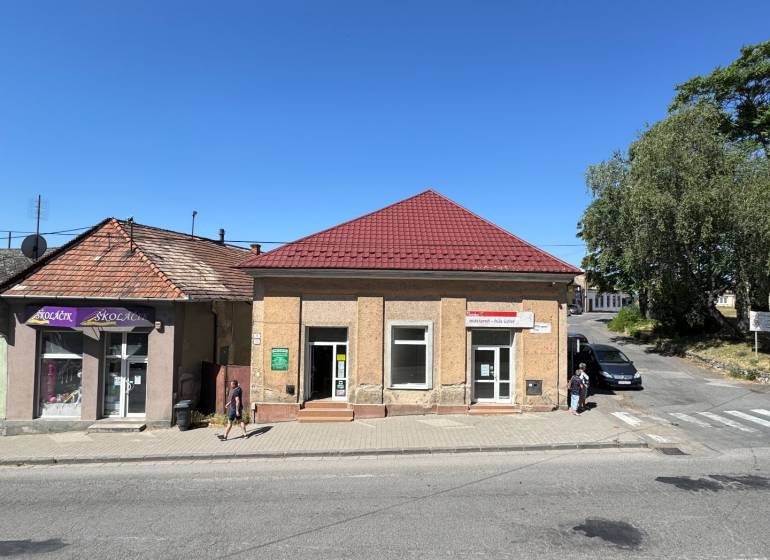 Obchodné priestory na predaj centrum mesta Šahy - Obchodné priestory na Hlavnom námestí v Šahách s červenou strechou a modrou oblohou.