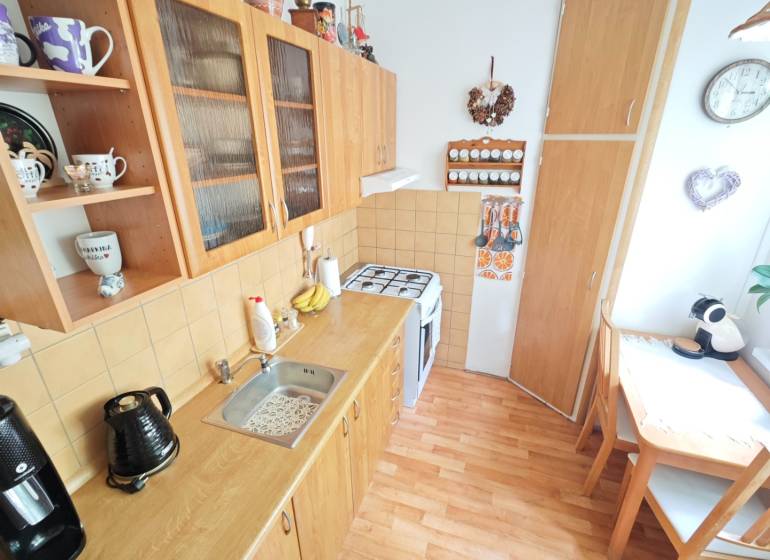 REZERVOVANÉ: 2 izb byt 56m2 pôvodný stav s balkónom, Družby Fončorda  - Kuchyňa v 2-izbovom byte s dreveným nábytkom, kútom na stolovanie a dekoráciami.