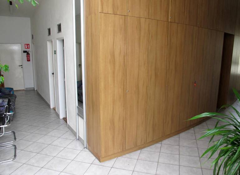 Kancelária 20 m2, Wolkrova ul., Petržalka - Interiér kancelárie s dlaždicovou podlahou a drevenými skriňami.
