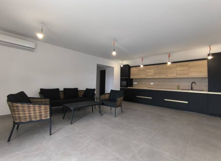 CHORVÁTSKO - Atraktívny apartmán (S6) - Mandre, ostrov Pag - Obývací priestor 4-izbového bytu s tmavým nábytkom a kuchyňou s drevenými detailmi.