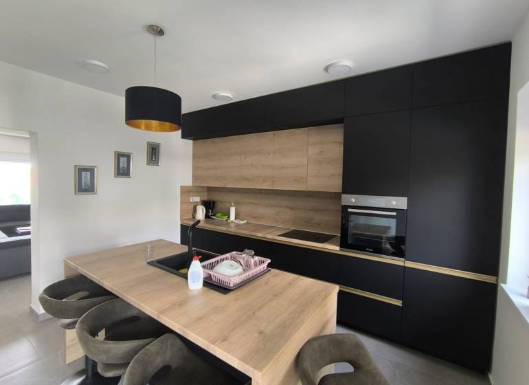 CHORVÁTSKO - Atraktívny apartmán (S4) - Mandre, ostrov Pag - Kuchyňa v 4-izbovom byte s tmavými skrinkami a drevenými detailmi.