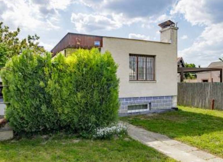 - EXKLUZÍVNE - REKREAČNÝ DOMČEK - ZLATÉ PIESKY  - Rodinný dom na ulici Mokráň záhon v Bratislave-Ružinove, obklopený zeleňou a trávnikom.