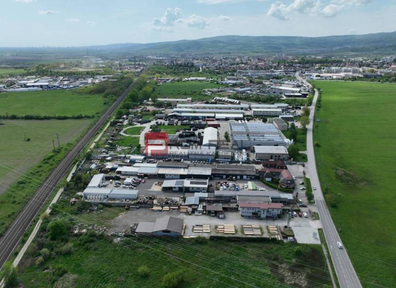Na PRENÁJOM areál vo výbornej lokalite Pezinok - Letecký pohľad na obchodné priestory na Šenkvickej ceste v Pezinku obklopené prírodou.