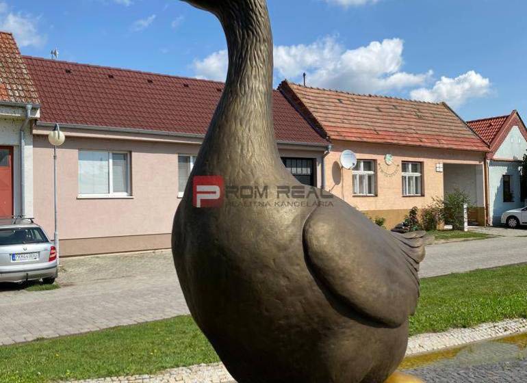 PRENÁJOM skladového priestoru 100m2 Slovenský Grob okres Pezinok - Socha husi s pozláteným vajcom, na ulici Slovenský grob, v pozadí sú sklady a haly.
