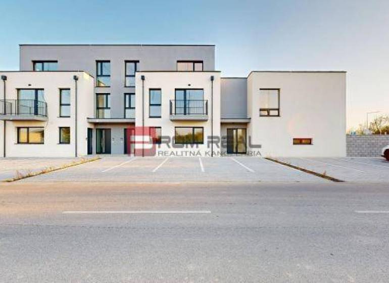 5 izbový RD - 128,33 m2 v novostavbe v Alžbetinom dvore - Budova na ulici Bottova, moderná architektúra, parkovisko a rodinný dom v pozadí.