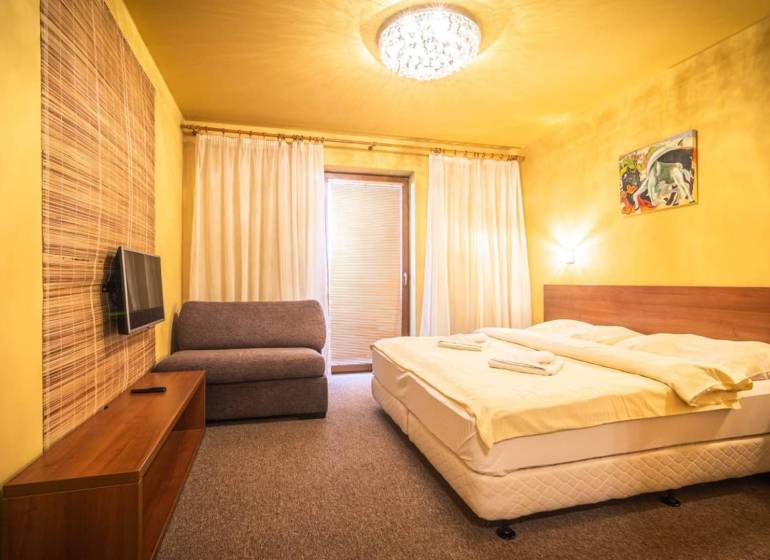 Príjemný apartmán s terasou v podhorí Vysokých Tatier - Spálňa v rekreačnom apartmáne s manželskou posteľou, pohovkou a televízorom.