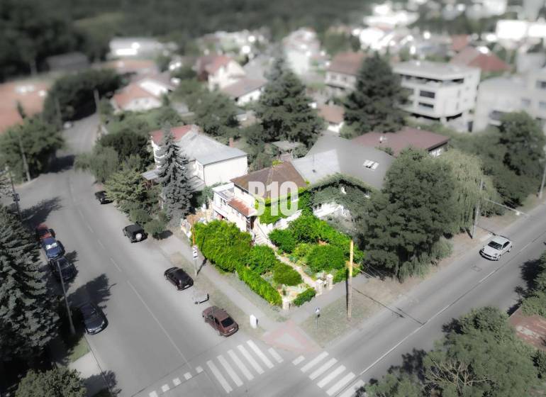 Predaj rodinného domu, Bratislava I - Rodinný dom v lokalite Bratislava - Staré Mesto, obklopený zeleňou a cestou s autami.