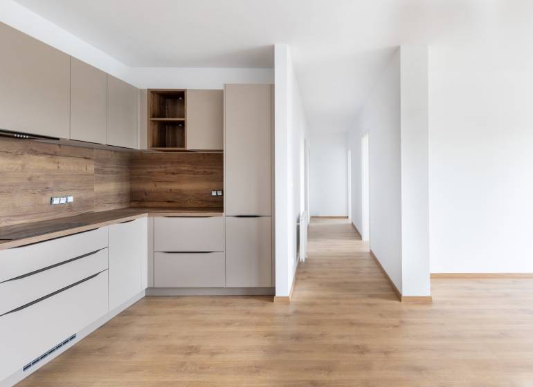 PRENAJOM | 3 Izbový byt + Loggia + Parking. PROMENADA LIVING PARK - Kuchyňa s drevenými prvkami a chodba v 3-izbovom byte, svetlé a minimalistické riešenie.