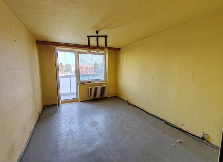 Komfortné bývanie s balkónom na Sídlisku Juh – váš nový domov čaká! - Žltá obývacia izba s balkónom v 3-izbovom byte.