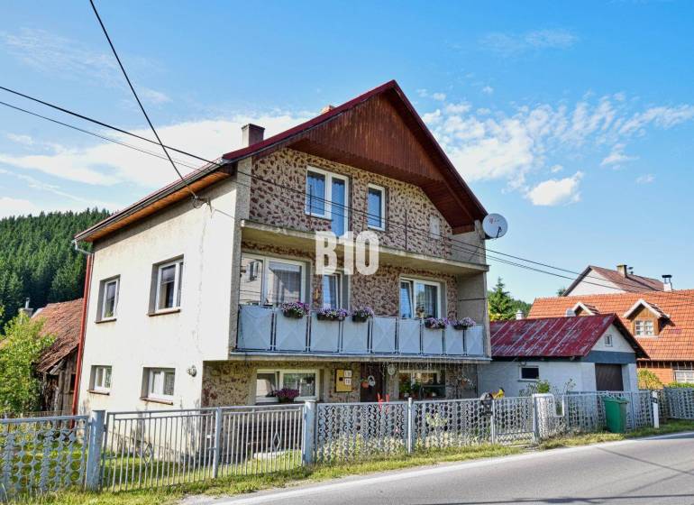 Predaj rodinného domu, Čadca - Rodinný dom v Turzovke s kvetmi na balkóne a satelitnou anténou.