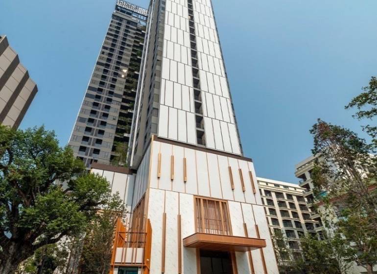 ONCE PATTAYA - Výstavba bytov v Pattayi, vysoká budova s modernou architektúrou a zeleňou okolo.