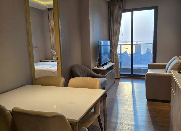 2 SPÁLŇOVÝ APARTMÁN ONCE PATTAYA - Jedálenský kút v 3-izbovom byte s pohľadom na obývaciu izbu a balkón.
