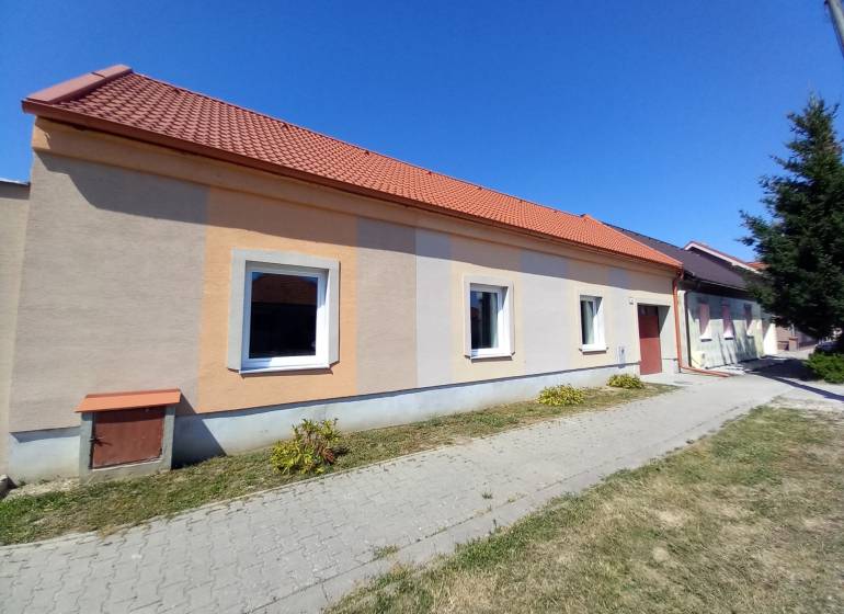 Na predaj zrekonštruovaný rodinný dom - Trakovice - Rodinný dom v Trakoviciach s oranžovou fasádou a červenou strechou.