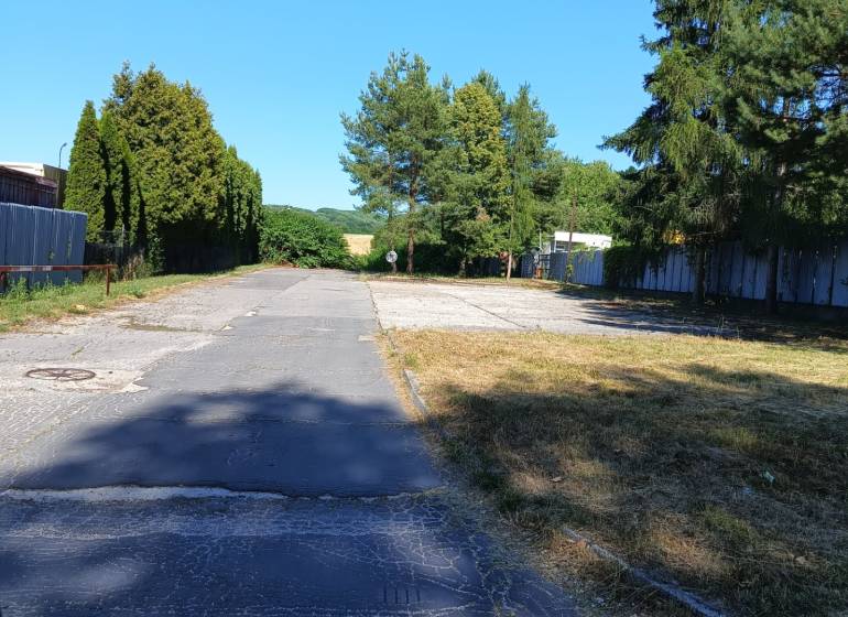 INVESTIČNÝ POZEMOK Prievidza - Asfaltová cesta obklopená stromami a zeleňou v Prievidzi, vhodná na pozemky - bývanie.