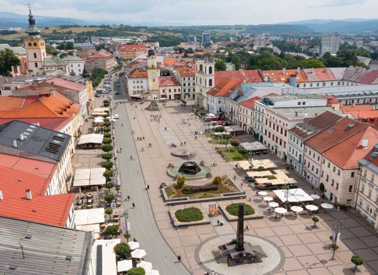 Kúpime VIDIECKÝ DOM s pozemkom v okolí Banskej Bystrice. - Na obrázku je námestie v Banskej Bystrici s reklamou na 1-izbový byt.