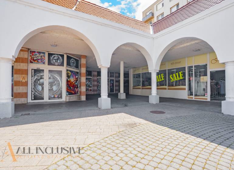 NA PRENÁJOM OBCHODNÝ PRIESTOR V CENTRE,DUNAJSKÁ STREDA - Obchodné priestory v Dunajskej Strede s oblúkovými arkádami a reklamou na zľavy.