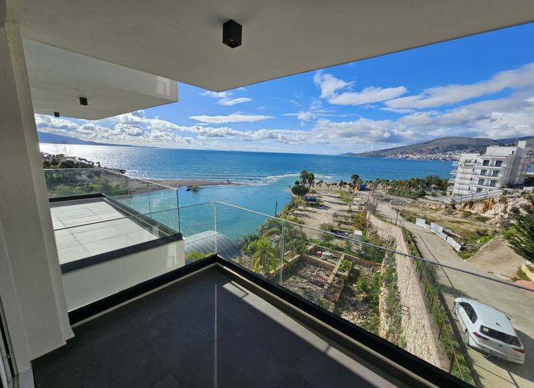  Albánsko, Sarandë – luxusné novostavby apartmánov v prvom rade - Balkón rekreačného apartmánu v Sarandë s výhľadom na more a pobrežnú krajinu.