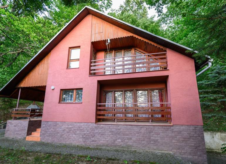 Exkluzívna chata pri Ružinej – výnimočná poloha s krásnym výhľadom - Drevená chata v Ružinej, obklopená zeleňou a s terasou na poschodí.