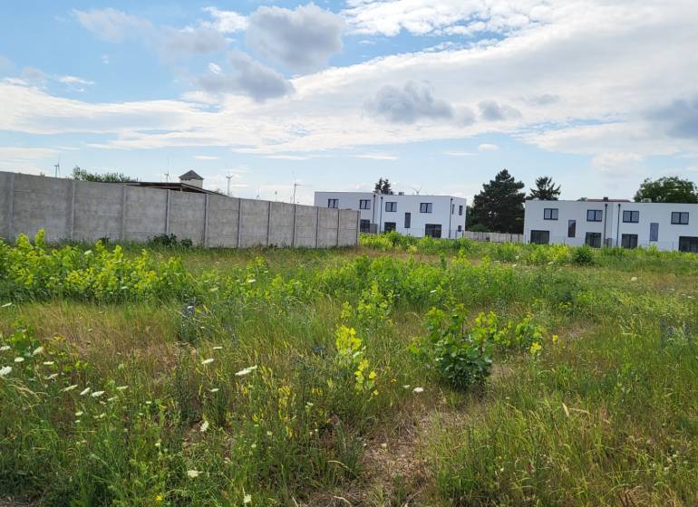Stavebný pozemok 545 m2, Potzneusiedl - Pozemky - bývanie v Potzneusiedli obkolesené zeleňou a modernými budovami v pozadí.