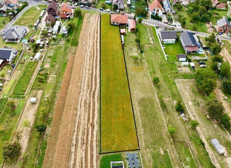 Na predaj investičný stavebný pozemok pre 3 RD, Trenč.Jastrabie - Letecký pohľad ukazuje pozemky na bývanie v Trenčianskom Jastrabí obklopené domami a záhradami.