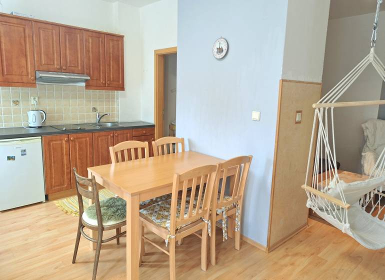 PREDAJ, Mezonetový apartmán v apartmánovom dome Horec, Donovaly - Kuchyňa so vstavanými skrinkami, jedálenským stolom a hojdacou stoličkou v 3-izbovom byte.