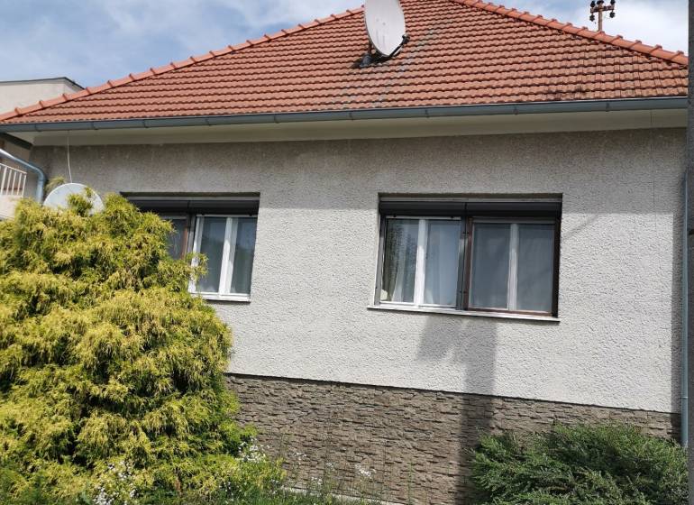 5 izbový rodinný dom Topoľčianky - Rodinný dom v Topoľčiankach so sedlovou strechou a satelitnou anténou.