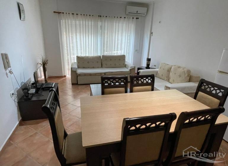 Sarandë - novozariadený apartmán v tesnej blízkosti mora - Interiér rekreačného apartmánu s jedálenským stolom, pohodlnými sedačkami a televíziou.