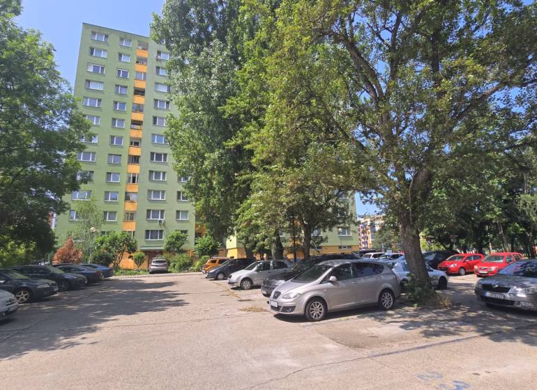 Predaj 3i byt, nepriechodné izby, Osuského ul., BA - Petržalka - Háje - Parkovisko v Bratislave - Petržalke na ulici Osuského s výhľadom na bytové domy и zeleň.