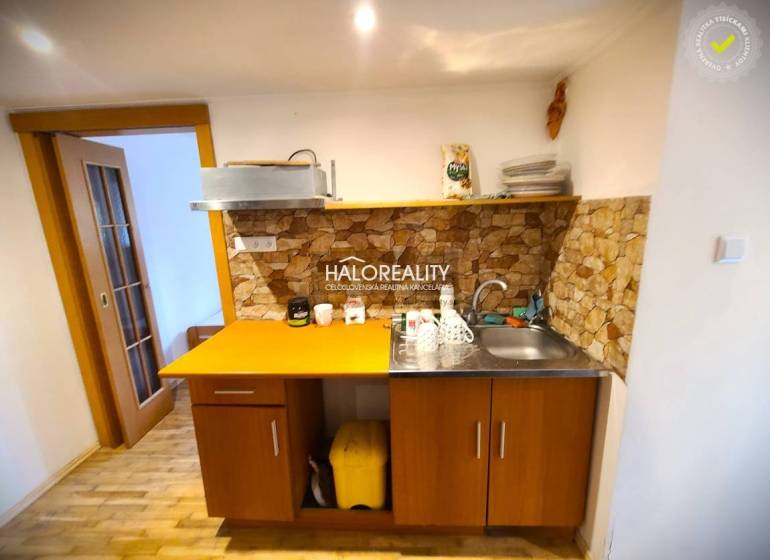 Predaj, rodinný dom Žilina, Budatín - Kuchyňa v rodinnom dome s dreveným nábytkom a kamenným obkladom.