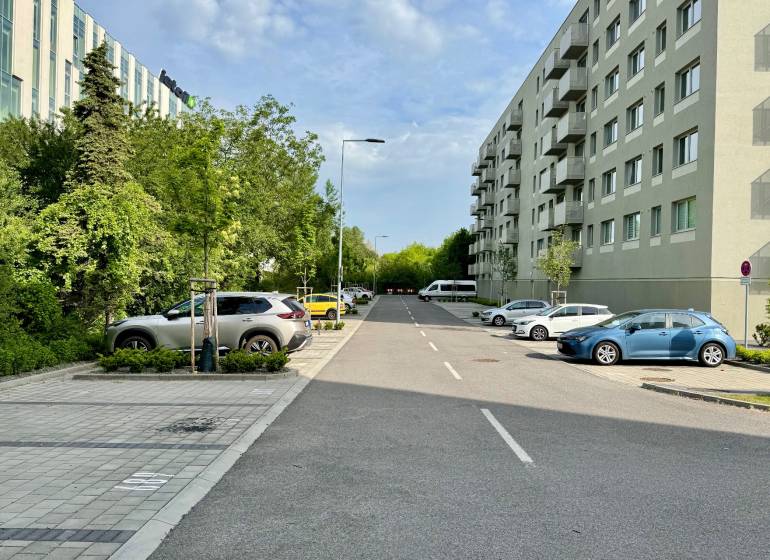 Vnútorné GARÁŽOVÉ STÁTIE, projekt OVOCNÉ SADY, 12 m2     - Cesta s autami a zeleňou v Bratislave-Trnávke na Ivánskej ceste, vedľa bytových domov.