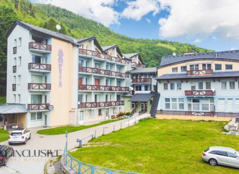 2 IZBOVÝ BYT S PANORAMATICKÝM VÝHĽADOM NA DONOVALY - Budova so štyrmi podlažiami a balkónmi na ulici Šafrán v Donovaloch.
