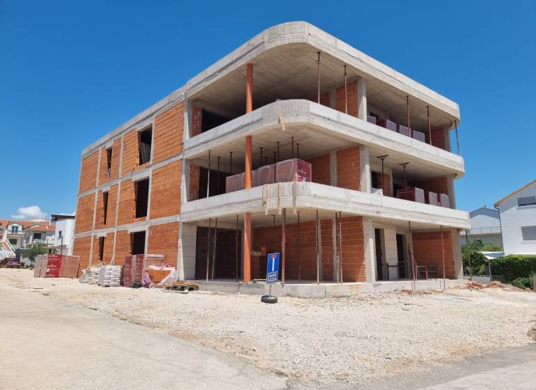 CHORVÁTSKO - Apartmány 140 m od pláže (4i) - VODICE - Rozostavaná budova so 3-izbovým bytom v meste Vodice za slnečného dňa.