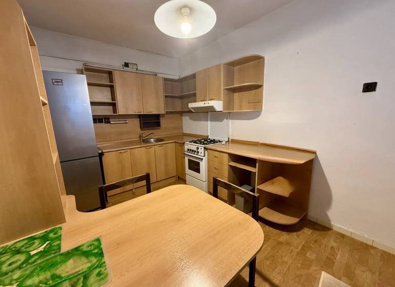 Jednoizbový byt s lodžiou, Žilina - Centrum - Kuchyňa v 1-izbovom byte vybavená drevenou nábytkom a chladničkou.