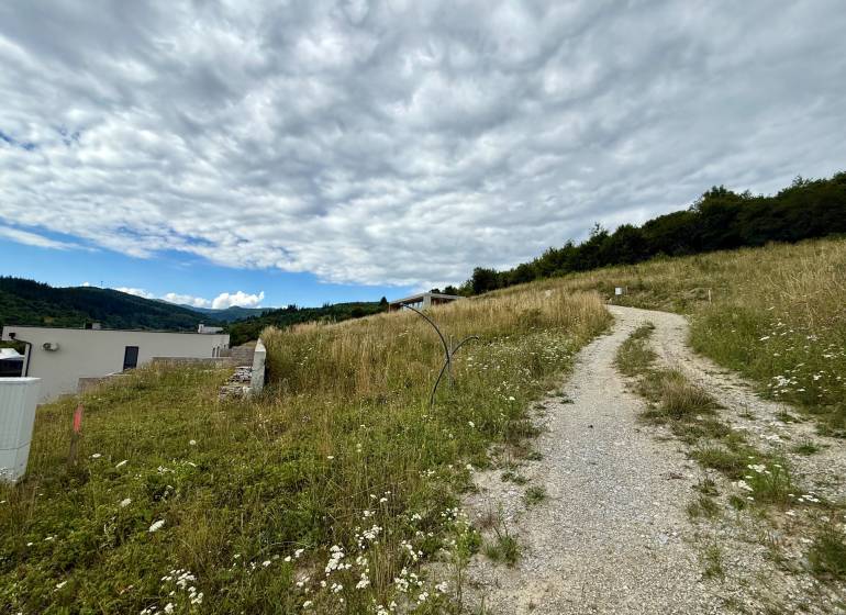 Stavebný pozemok v Divinke - Žilina - Pozemky - bývanie v Divinke s vidieckou cestou a panoramatickým výhľadom na krajinu.