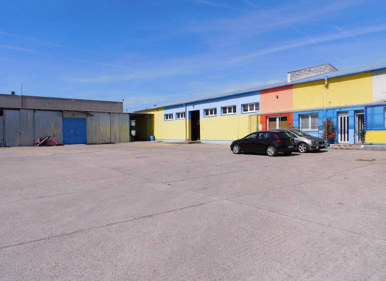 Prenájom skladu a haly, Trnava - Farebné budovy skladov a hál v Trnave s parkoviskom a autami.