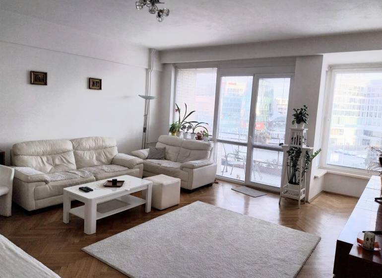 Štýlový  4 izbový  - terasa- lodžia , výťah v centre BA. - Svetlá obývačka s bielymi pohovkami v 4-izbovom byte, presklené dvere na terasu.