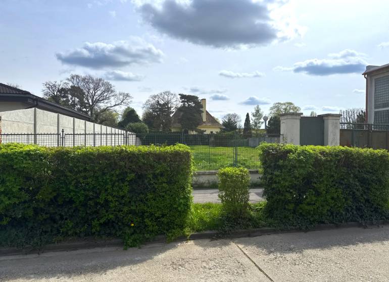 Pozemok 1315 m² pre rodinný dom blízko centra – Sládkovičovo - Pozemky - bývanie v Sládkovičove, za zeleným plotom sa nachádza priestranná lúka.