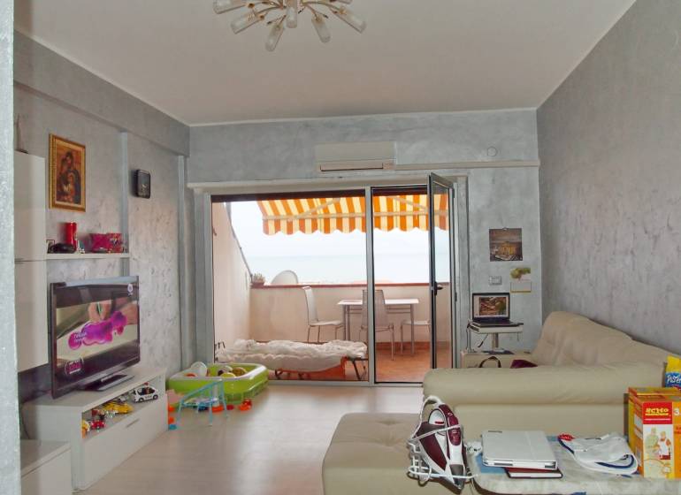 Predaj bytu 3-izbového (3+kk) s rozlohou 65 m² a terasou 10 m², Scalea - Obývačka v 3-izbovom byte s terasou, televíziou a pohodlnými sedačkami.