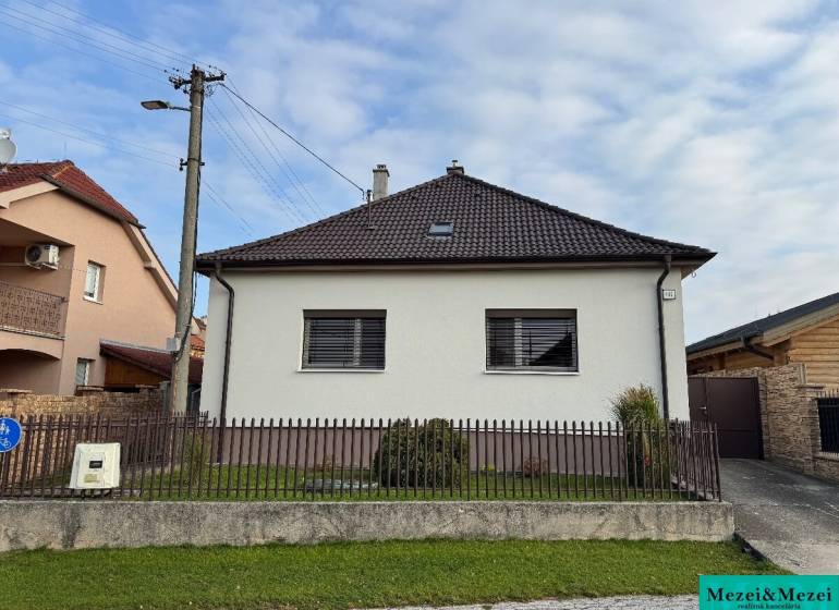 ? Na predaj: Rodinný dom s vedľajšou stavbou – Trstin (okres Trnava) - Rodinný dom v Trstíne so šikmou strechou, oplotenie a trávnatá plocha pred domom.