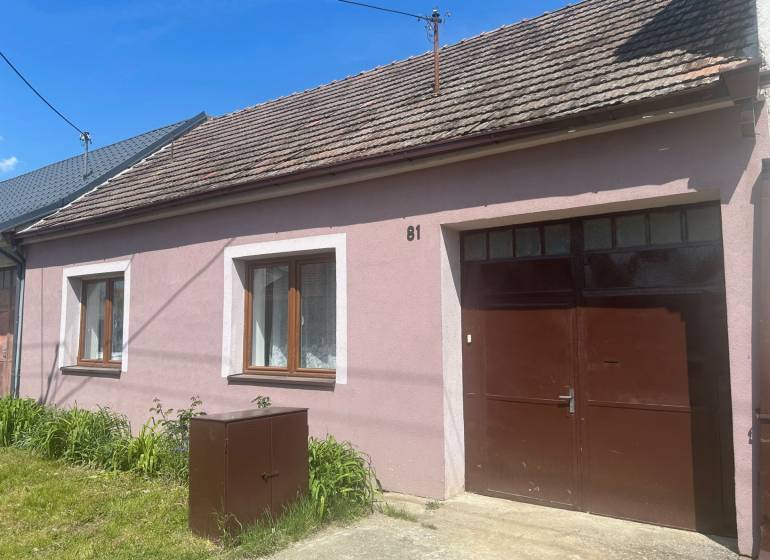 PREDAJ DOMU V ŠTEFANOVEJ S VEĽKÝM POZEMKOM - 2 399 m2 - Rodinný dom na Hlavnej ulici v Štefanovej má ružovú fasádu a trávnik.
