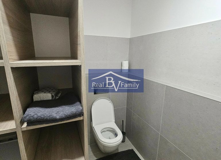 PRENAJATÉ - PRENÁJOM, BOTTOVA, STARÉ MESTO - 2 IZBOVÝ BYT - Kúpeľňa v 2-izbovom byte s toaletou, bielymi stenami a úložnými priestormi v drevenom dekore.