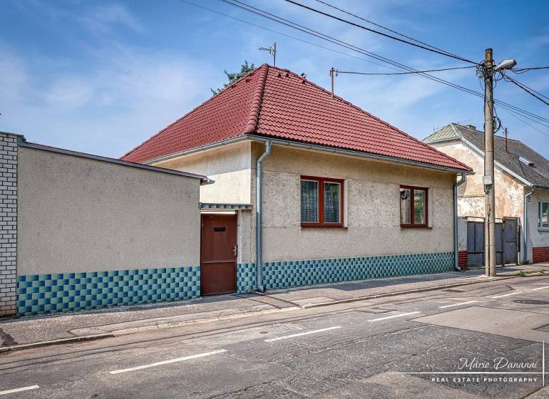 VÝRAZNÁ ZĽAVA 4-izbový rodinný dom na Kopánke v Trnave - Rodinný dom v Trnave s bielou fasádou a červenou strechou na ulici v Trnave.