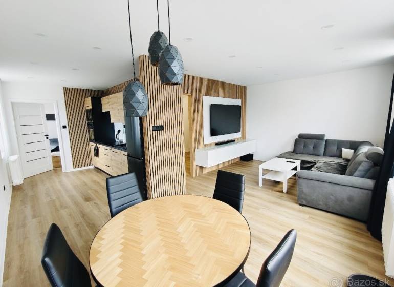 NA PRENÁJOM NOVOZREKONŠTRUOVANÝ 2-IZBOVÝ BYT, UL. ROŽŇAVSKÁ - Štýlový interiér 2-izbového bytu s podlahou s dreveným dekorom a pohodlnou sedačkou.