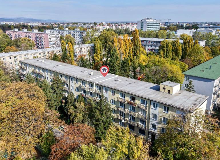 SEČOVSKÁ, 2-i tehlový byt, 56 m2, orientácia V a Z - OBKLOPENÝ ZELEŇOU - Pohľad na bytový dom obklopený zeleňou v Bratislave - Ružinove na Sečovskej.